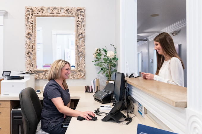 receptionist at Koplon Family Dentistry greeting a patient for an appointment